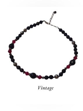 Vintage beaded necklace with red and black faceted beads and silvertone accents.
